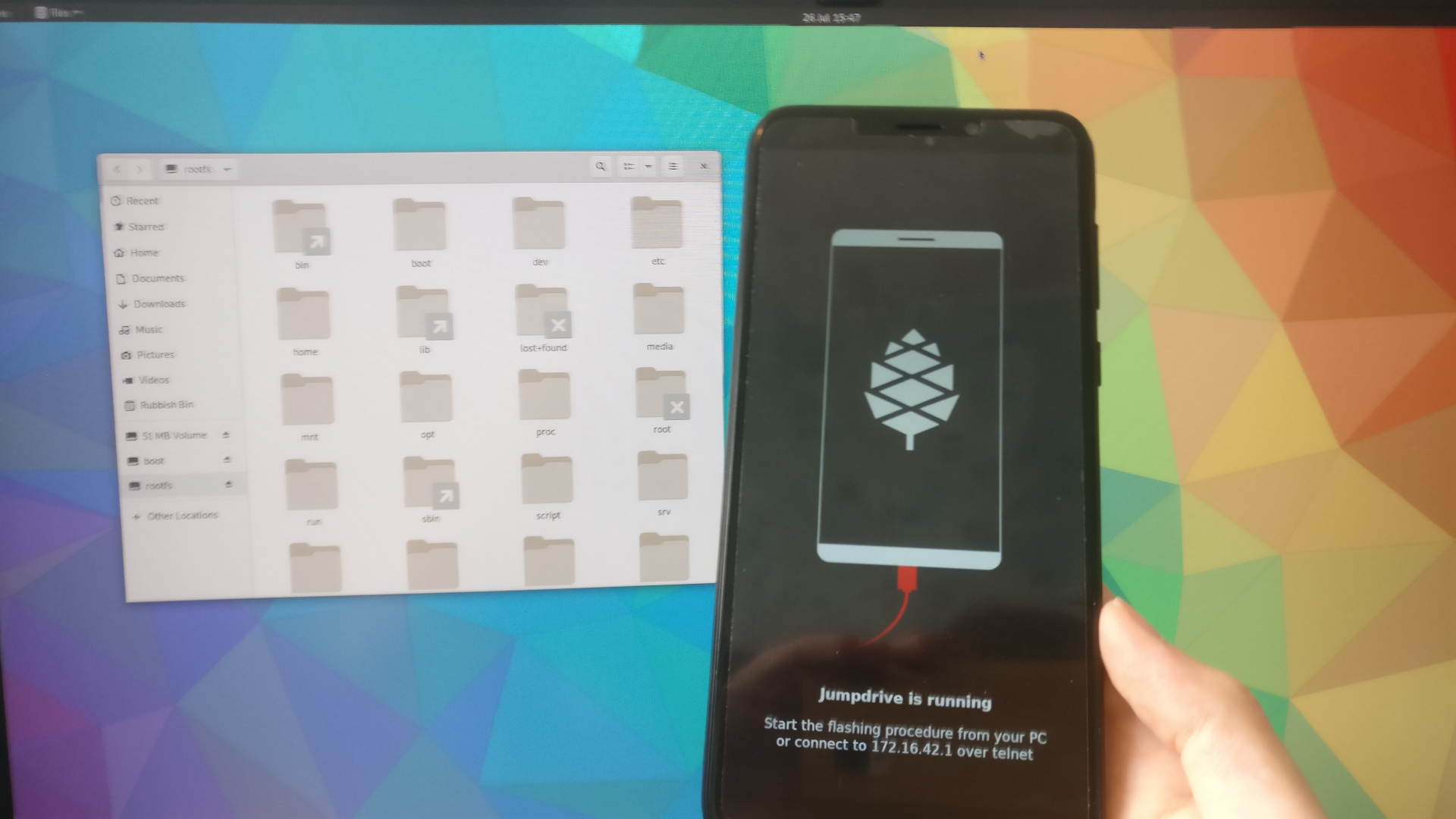 Jumpdrive running on the phone, with its filesystem shown on the monitor in the background.